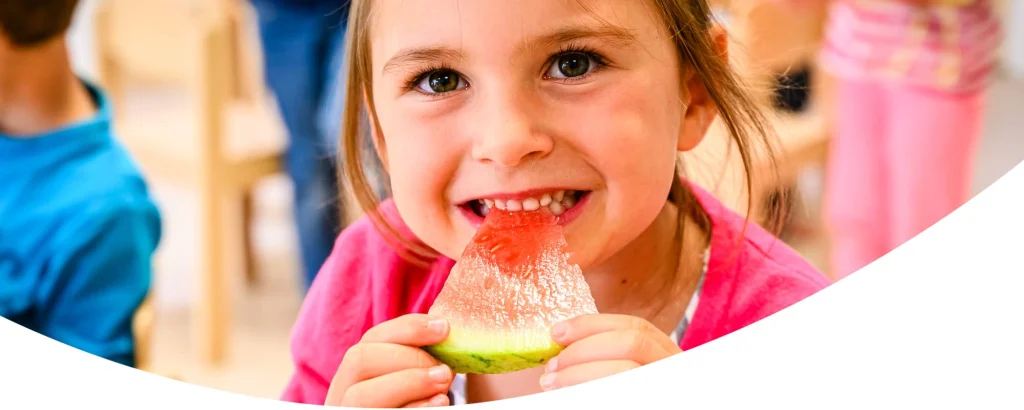 Mädchen isst ein Stück Wassermelone